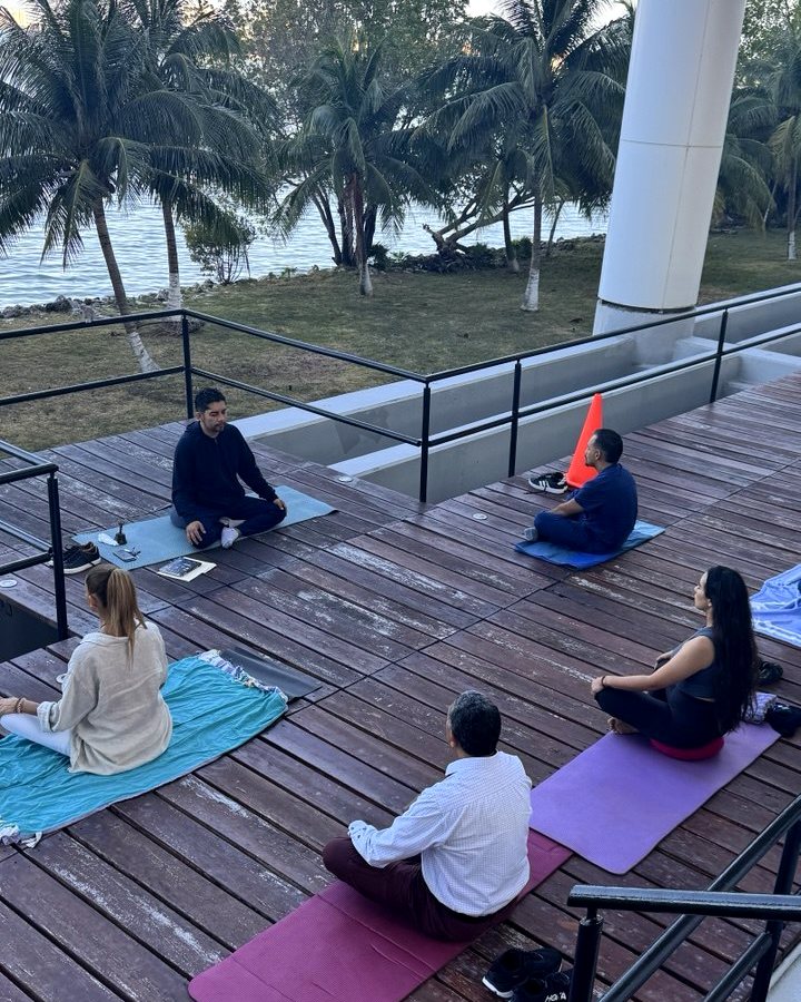 Anuar Mena guiando una práctica de meditación al aire libre, frente a la bahía